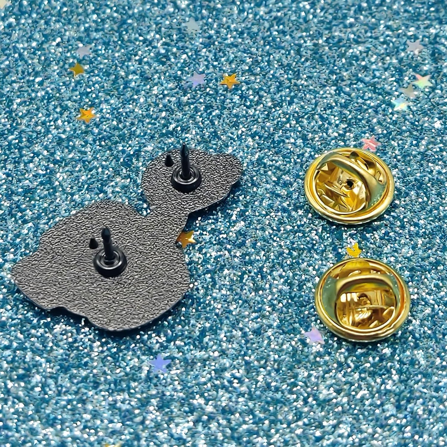 Two metallic pins on a glittery blue background