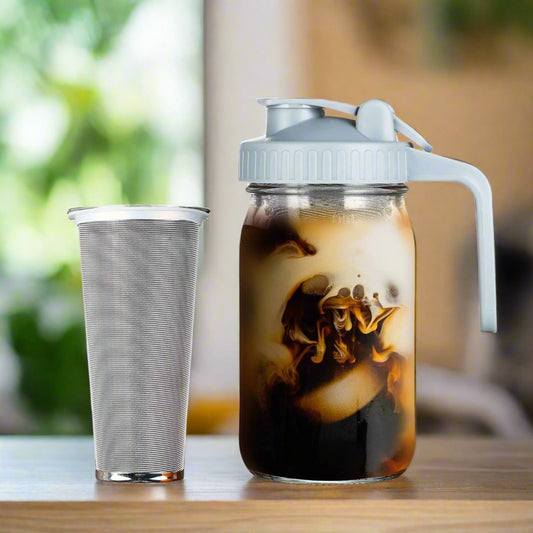Glass jar with a white lid filled with iced coffee on a white background